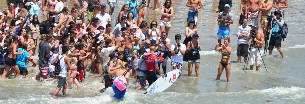 View of beach as fans greet a pro surfer